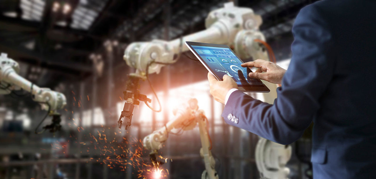 JANA, Inc. homepage image (1) - man in jacket uses tablet to control robotic arms