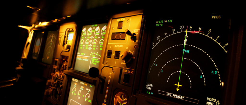 This picture shows a dimly-lit airplane cockpit panel.
